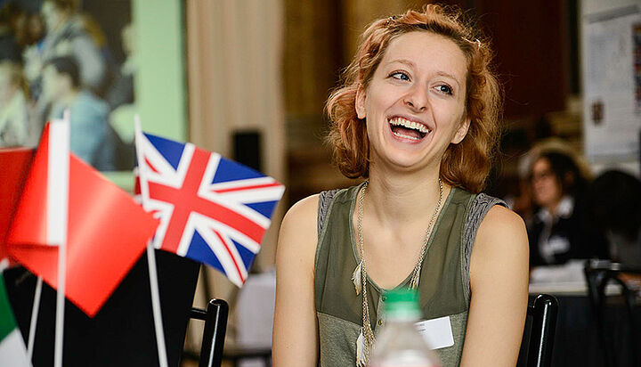 different flags in front of a smiling student